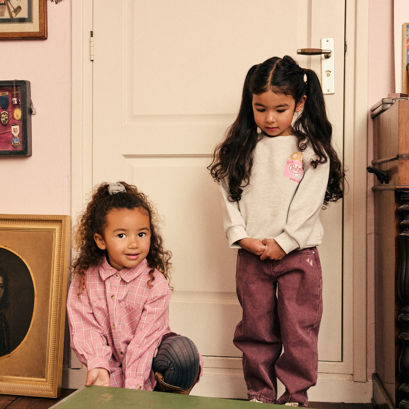 Twee meisjes ontdekken een vintage geïnspireerd interieur in kleurrijke outfits uit de Daily7 Kids collectie.